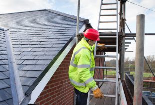 A worker from 5 Star Roofcare is seen on a ladder, diligently working on a roof.