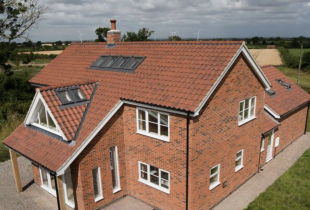 A red brick house with sunroofs showcasing the excellent work by 5 Star Roofcare.