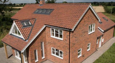 A red brick house with sunroofs showcasing the excellent work by 5 Star Roofcare.