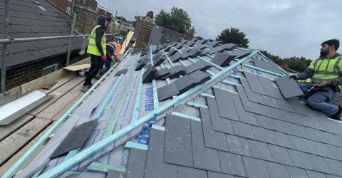 Men from 5 Star Roofcare diligently working on a slate roof, ensuring quality and precision.